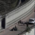In this Dec. 16, 2018, file photo, Honduran asylum seekers are taken into custody by U.S. Border Patrol agents after the group crossed the U.S. border wall into San Diego in this view from Tijuana, Mexico. (Moises Castillo/The Associated Press)