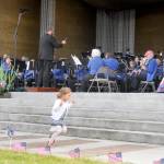 While her father Tyler Benedict directs the Sequim City Band, 2-year-old Amelia Benedict enjoys the music at the bands traditional 4th of July Concert on Thursday afternoon. (Mike Dashiell/Olympic Peninsula News Group)