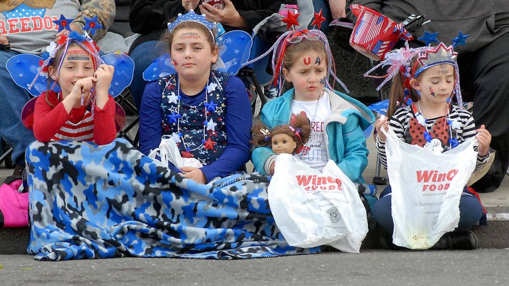 Parade-goers, from left, Amrti Atkinson, 7, Makaylah Bates, 9, Maddi Atkinson, 5, all of Seabeck, and Alexandriah Bates, 5, of Bremerton wait on the curb with candy collection sacks at the start of Thursdays Independence Day parade in Port Angeles. (Keith Thorpe/Peninsula Daily News)