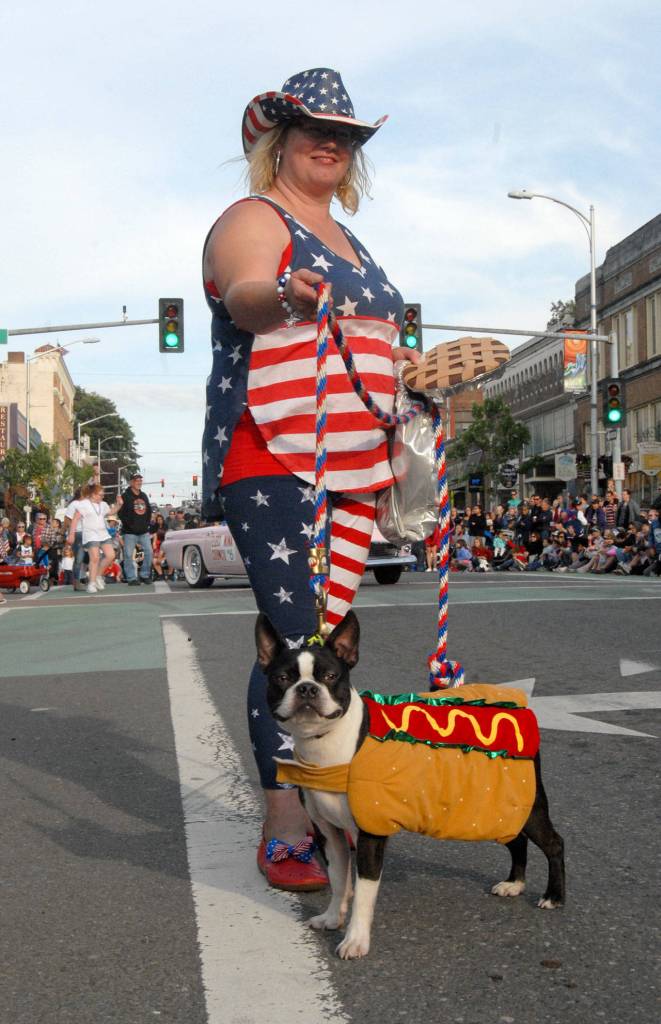 Andrea Donisi, along with her hot dog, Myer, marches with the Port Angeles Lefties parade entry on the Fourth of July. (Keith Thorpe/Peninsula Daily News)