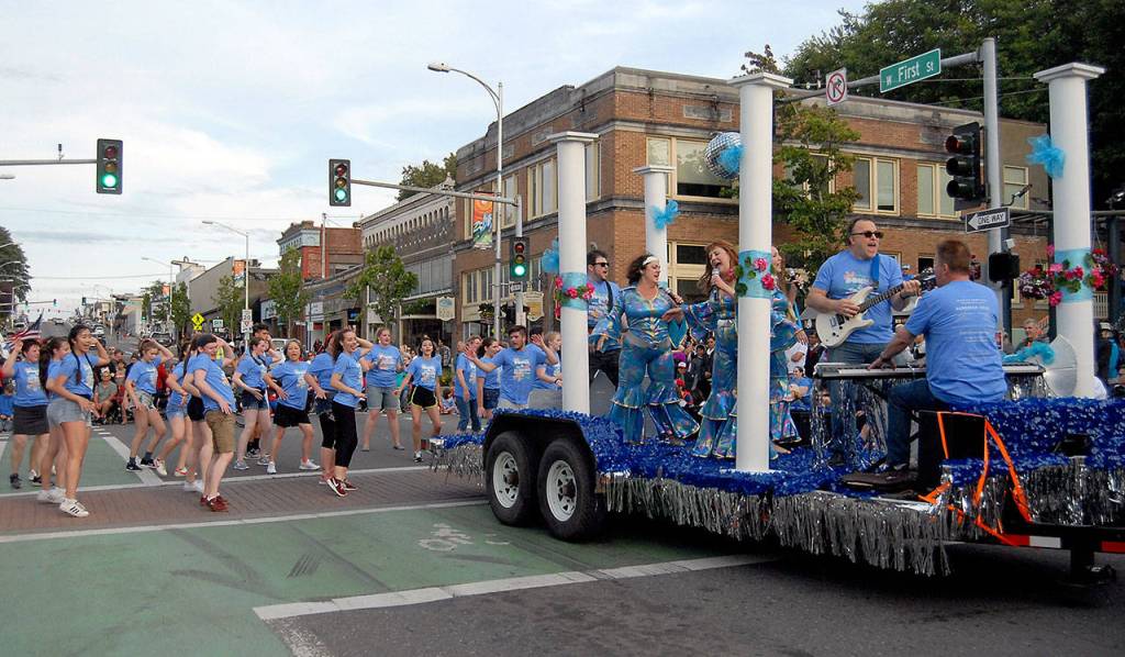 Cast members of the Ghostlight Productions musical Mamma Mia! dance for parade-goers on Thursday evening. (Keith Thorpe/Peninsula Daily News)