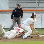 Keith Thorpe/Peninsula Daily News Wilder first baseman Bo Bradow receives a wild throw from the mound as Australia Red baserunner Ryan Hudson dives back to base during the fourth inning on Saturday night at Port Angeles Civic Field.