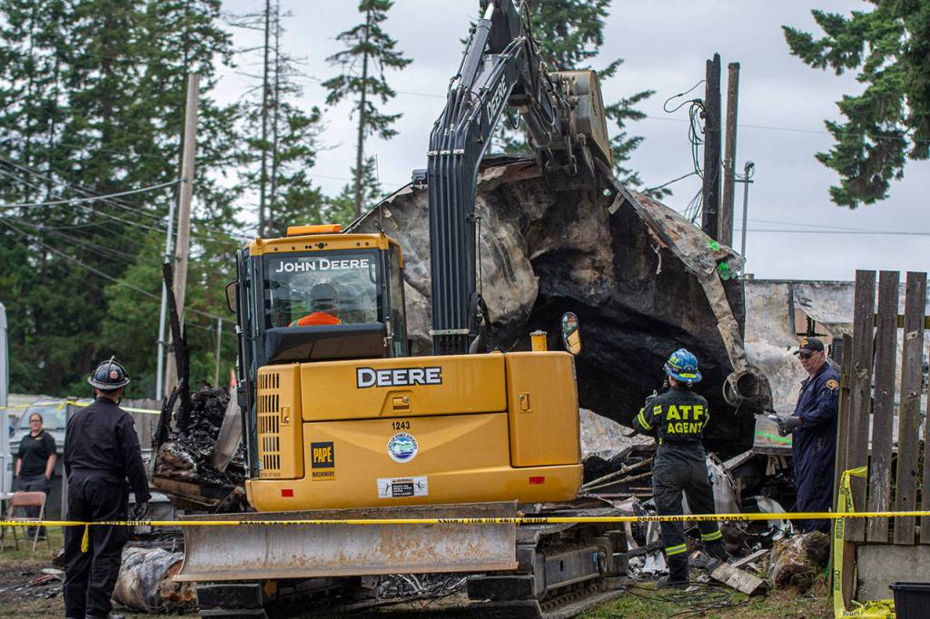 Crews on Sunday remove the roof from one of the mobile homes that caught fire in Port Angeles Saturday. (Jesse Major/Peninsula Daily News)