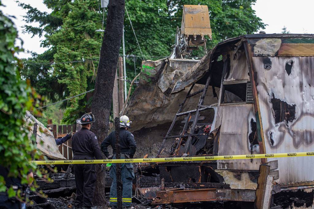 Crews on Sunday remove the roof from one of the mobile homes that caught fire in Port Angeles on Saturday. (Jesse Major/Peninsula Daily News)