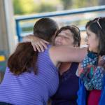 Holly Wright, a friend of Valerie Kambeitz and her children Lilly, Emma and Jayden Kambeitz, receives a hug during a vigil in their honor Monday. (Jesse Major/Peninsula Daily News)