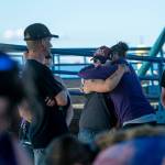 Two people embrace during a vigil for Valerie Kambeitz and her children Lilly, Emma and Jayden Kambeitz on Monday. (Jesse Major/Peninsula Daily News)