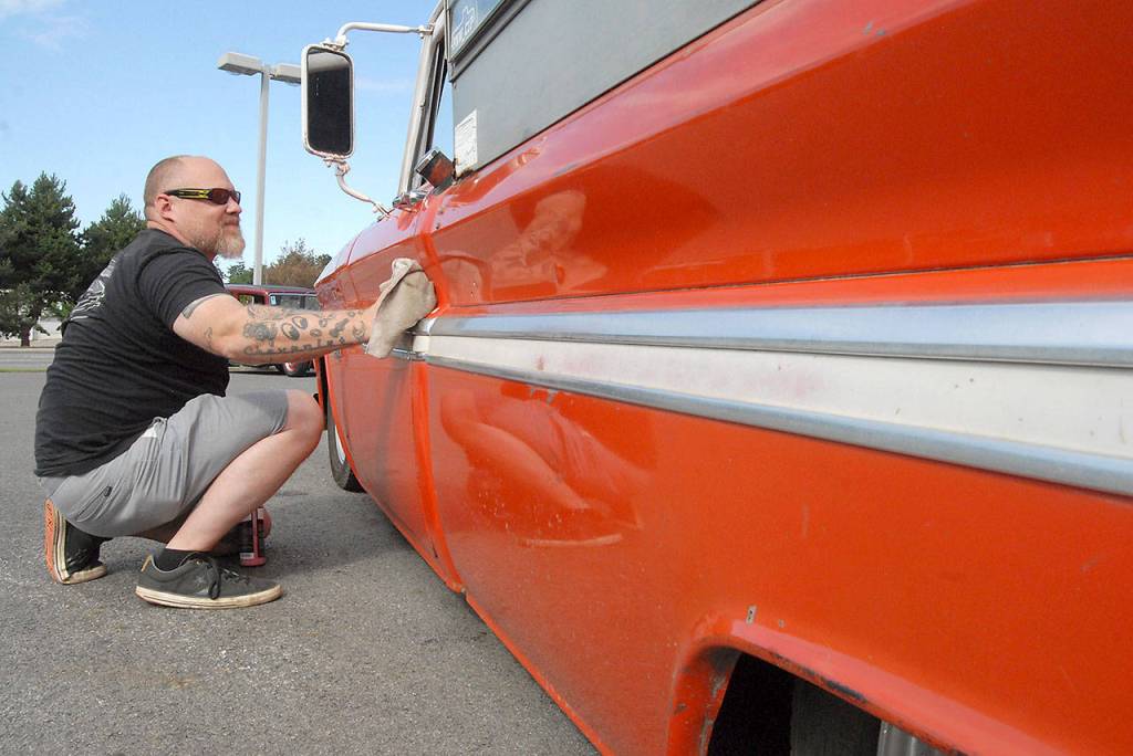 Todd Manchester of Port Angeles wipes down the side of his 1966 Chevrolet pickup before displaying it at the Ruddell Cruise-in on Friday in Port Angeles. (Keith Thorpe/Peninsula Daily News)