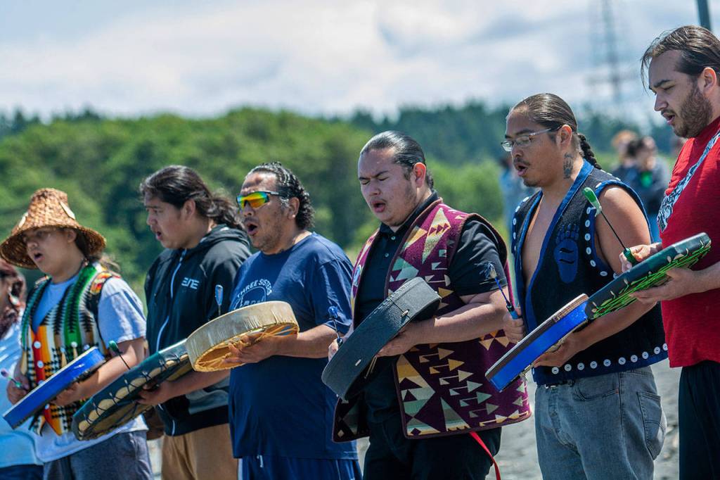 Members of the Lower Elwha Klallam Tribe sing as canoes begin to land at the tribes reservation during the Paddle to Lummi on Sunday. (Jesse Major/Peninsula Daily News)