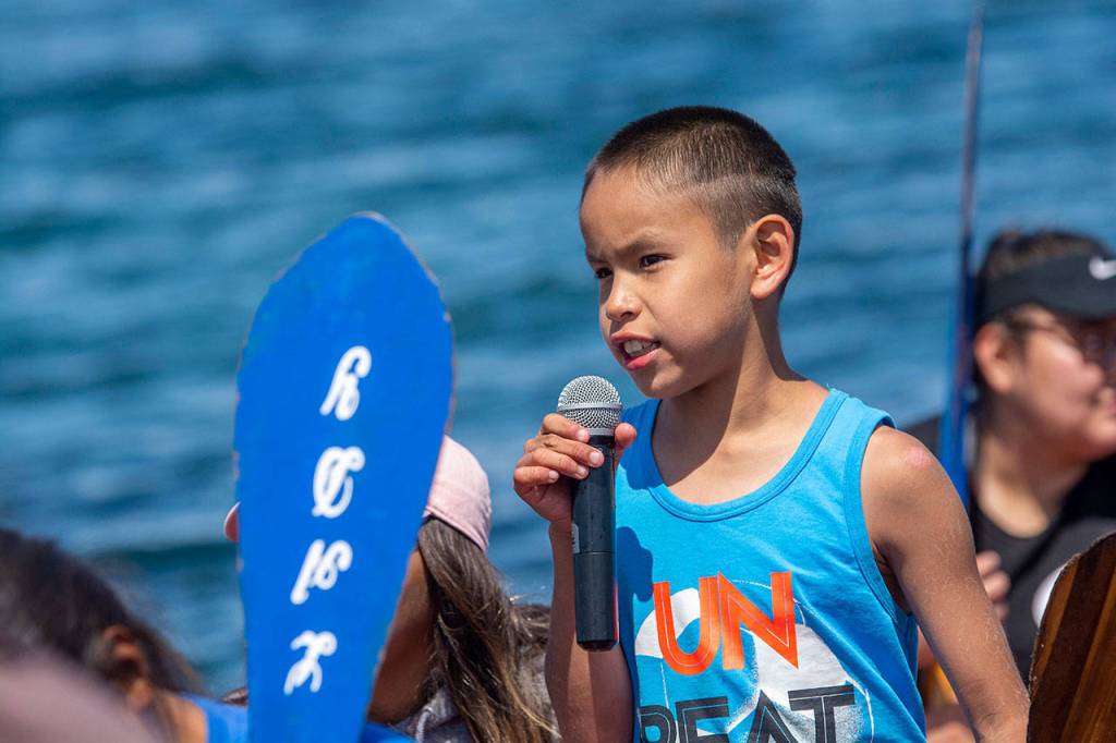Darnell Tom of the Ahousaht Tribe, 10, requests permission to land at the Lower Elwha Klallam Tribes reservation Sunday during the Paddle to Lummi. (Jesse Major/Peninsula Daily News)