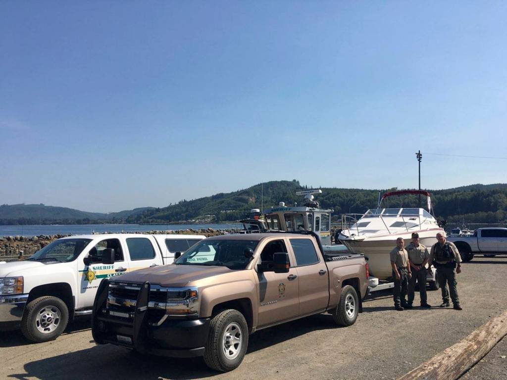 State Department of Fish and Wildlife Officials stand near a boat seized following fishing violations off Sekiu last summer.
