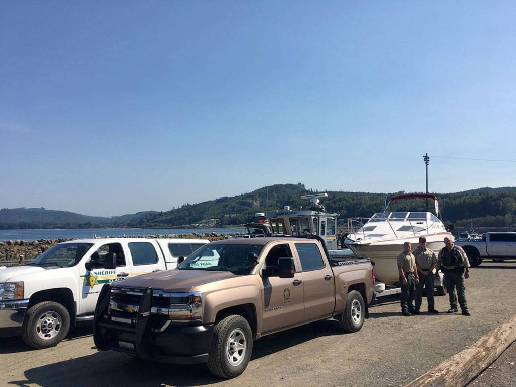 Officials with the Clallam County Sheriffs Department Marine Patrol Unit and the state Department of Fish and Wildlife stand near a boat seized following fishing violations off Sekiu last summer.                                State Department of Fish and Wildlife