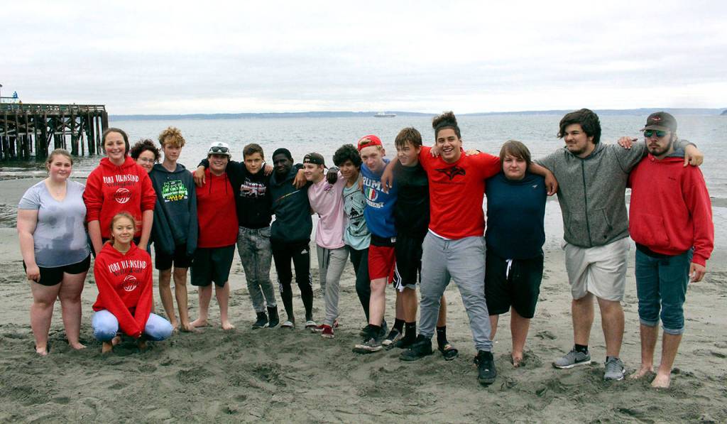 Port Townsend High School athletes volunteered their time to assist with pulling the canoes out of the water and carry them up the beach. (Zach Jablonski/Penninsula Daily News)                                Port Townsend High School athletes assist with pulling the canoes out of the water and carry them up the beach. (Zach Jablonski/Penninsula Daily News)