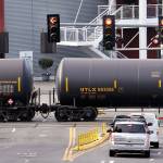 In this 2018 photo, automobile traffic waits at a train crossing as train cars that carry oil are pulled through downtown Seattle. (Elaine Thompson/The Associated Press)