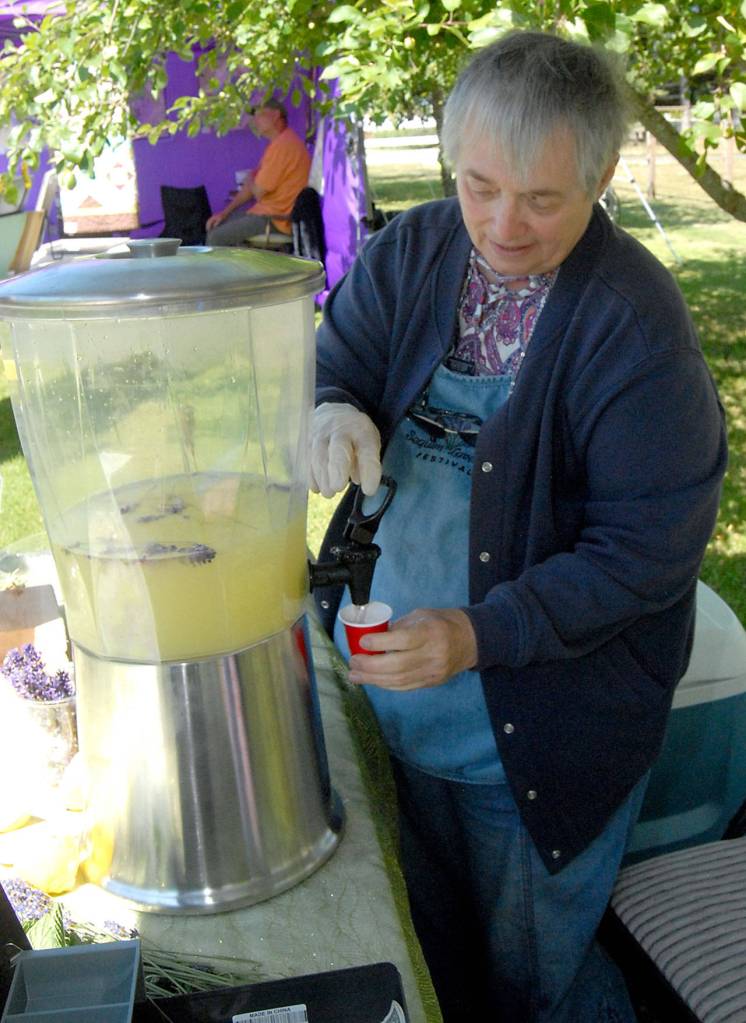 Kitty Bs Lavender Farm volunteer Lynda Tripp pours a sample of lavender lemonade Saturday during Lavender Weekend. (Keith Thorpe/Peninsula Daily News)