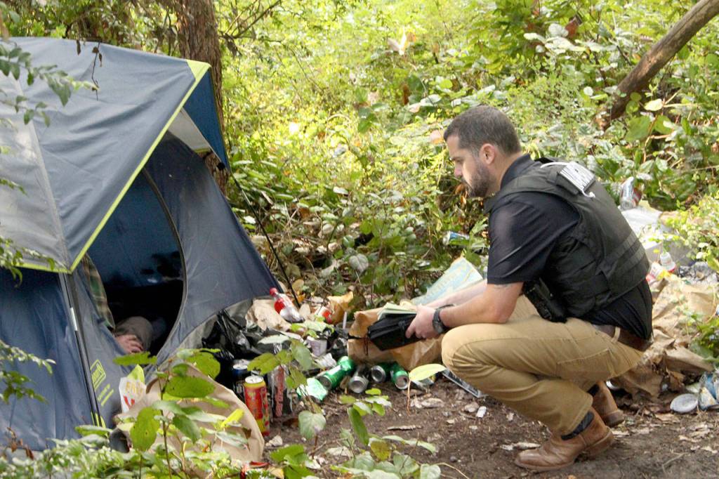 Navigator Jud Haynes speaks to a homeless man about what help he needs and what his plans are after leaving the property. (Zach Jablonski/Peninsula Daily News)