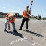 Scot Clark, left, and Trey Hoover of Sequim-based Clark Land Office locate and mark the location of a future wheelchair ramp at the corner of East 13th Street and Lauridsen Boulevard in preparation for improvements to Lauridsen scheduled to begin Monday. (Keith Thorpe/Peninsula Daily News)