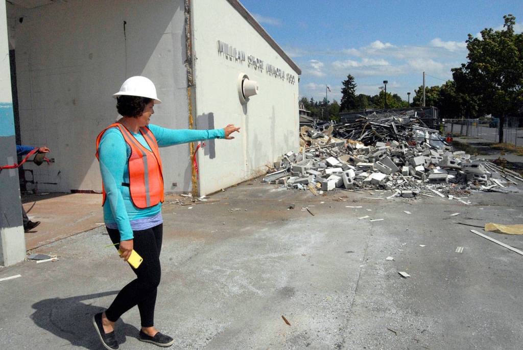 Shore Pool Project Manager Jessica Compton points out a pile of rubble from a former concession stand during a tour of the pool site Friday. (Keith Thorpe/Peninsula Daily News)