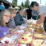 Blackberry pie judges, from left, Blackberry Cafe owner Roxanne Olsen, Crescent School principal Therese Carroll, and Peninsula Daily News publisher and Sound Publishing vice-president Terry Ward receive pie samples from contest organizer Deb Moriarity, right.                                Slices of pie await purchase by Joyce Daze Wild Blackberry Festival visitors.