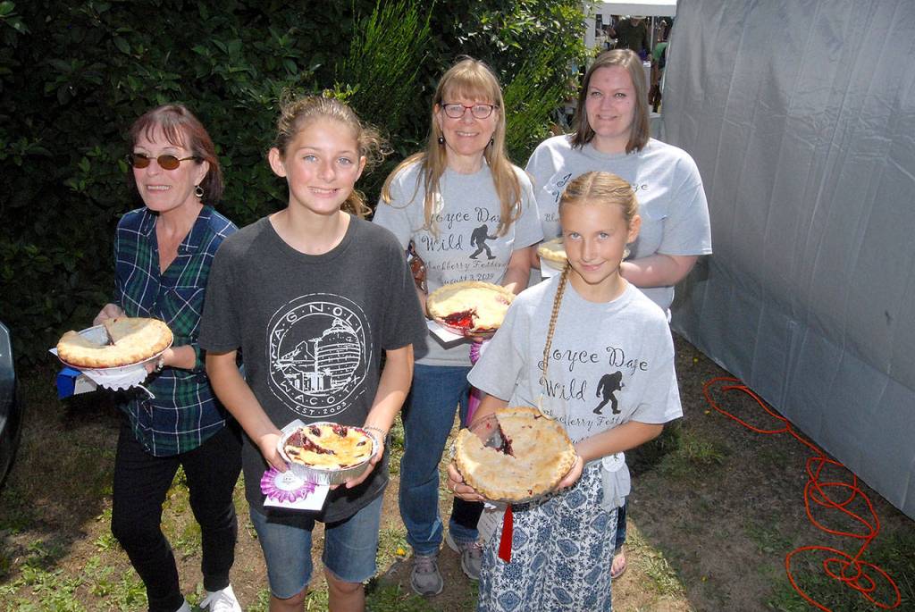 Wild blackberry pie contest winners display their entries after judging on Saturday. The adult category winners were, back row from left, Teresa Harris of Joyce taking first, Janice Harsh of Joyce in second and Tamara Stephens of Portland, Ore., taking third. In the youth competition, Paige McCafferty, 12, of Caldwell, Idaho, front left, took third and Lily Robertson, 11, of Joyce, front right, placed second. Youth winner, Nick Ellison of Lewes, England is not pictured.