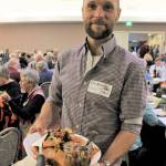 Event volunteer Erik Kingfisher carries a platter of local foods at the 2018 Friends of the Fields Harvest Dinner. (North Olympic Land Trust)