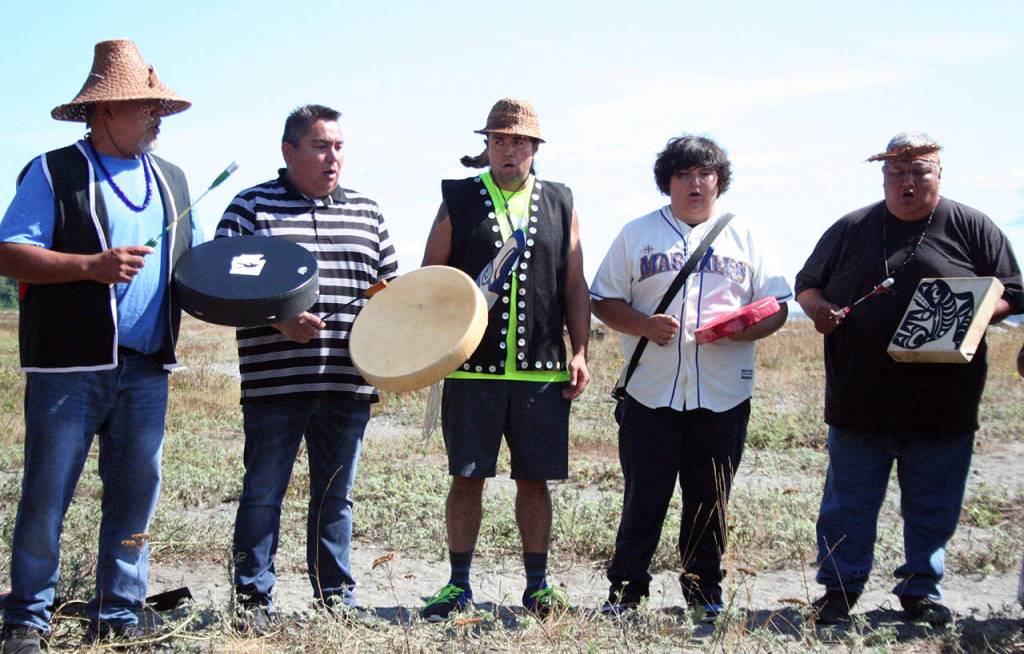 The SKlallam Singers, including Port Gamble SKlallam Tribal Council Chairman Jeromy Sullivan, second from left, performed two songs on Isthmus Beach at the start of Mondays groundbreaking ceremony. (Brian McLean/Peninsula Daily News)