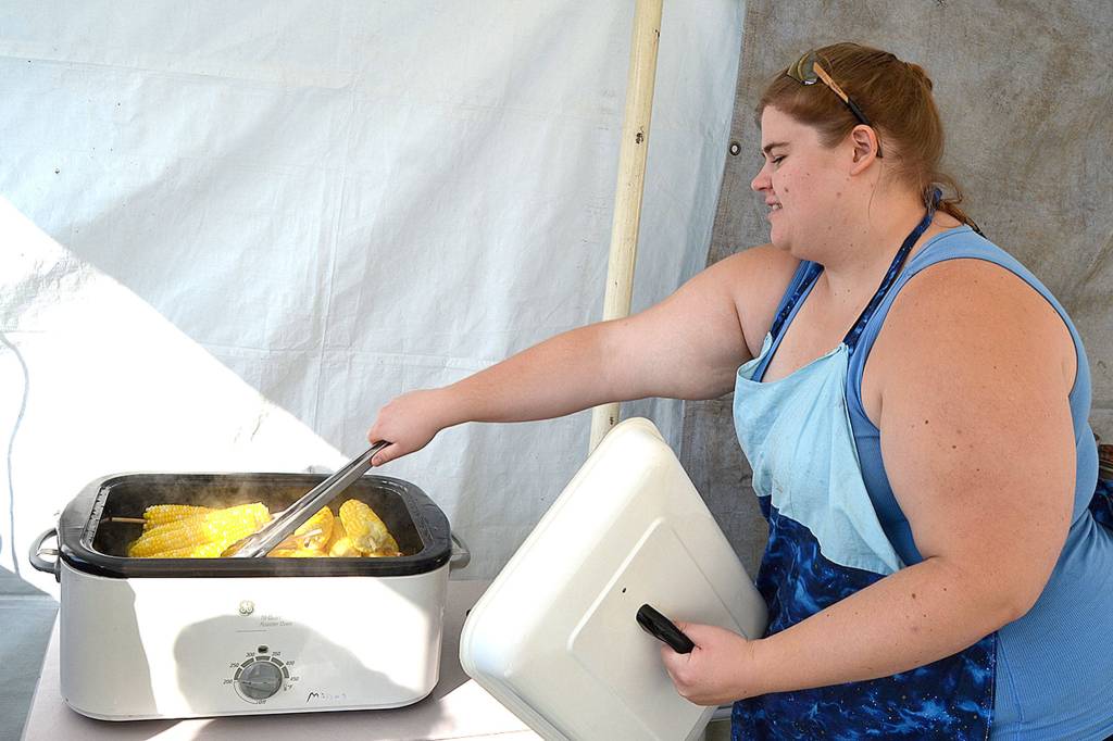 Lindsey Carlson, a majority member of the Sequim Rainbow Girls, readies some corn on the cob for the clubs annual booth at the 2018 Clallam County Fair. (Matthew Nash/Olympic Peninsula News Group file)