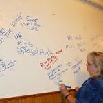 DeAnna Stossel, a long-time customer at the Cornerhouse Restaurant, writes a farewell message on the walls in the bar area of the eatery at its closing party. (Dave Logan/for Peninsula Daily News)