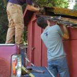 Eagle Scout candidate Ian Thill and Sergio Yanez work on removing a section of the lower roof of the Pioneer Memorial Park storage shed.