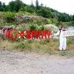 Lissy Andrews of Port Townsend, left, and a Seattle woman who identifies herself as Hogan stage a protest of aerial herbicide spraying just off state Highway 20 south of Anderson Lake Road on Monday. (Brian McLean/Peninsula Daily News)