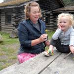Anya Samawicz of Port Angeles plays with a dandelion with her daughter, Sunny Eckenberg, 2 1/2, outside the former Loomis Tavern building at Lincoln Park, the site where she plans to start an outdoor preschool for pre-kindergarten children. (Keith Thorpe/Peninsula Daily News)