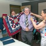 Jefferson County Quilts of Valor members Kathey Bates, left, and JoEllen Thompson, on right, assisted by Renee Tyler present a quilt to former U.S. Navy hospital corpsman William Jeffrey at the VA clinic in Port Angeles.