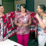 Renee Tyler, left, assists JoEllen Thompson of Jefferson County Quilts of Valor, on right, with the presentation of a quilt to former U.S. Navy mineman Tracy Delacruz. Delacruz is an RN at the VA clinic in Port Angeles.