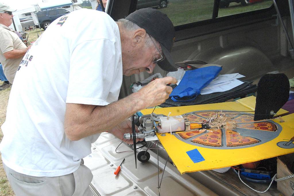Bob Walter of Port Angeles makes repaires on a novelty radio-controlled airplane make from a piece of plastic painted to look like a pizza box during a flying demonstration hosted by the Port Angeles-based Olympic R/C Modelers. (Keith Thorpe/Peninsula Daily News)