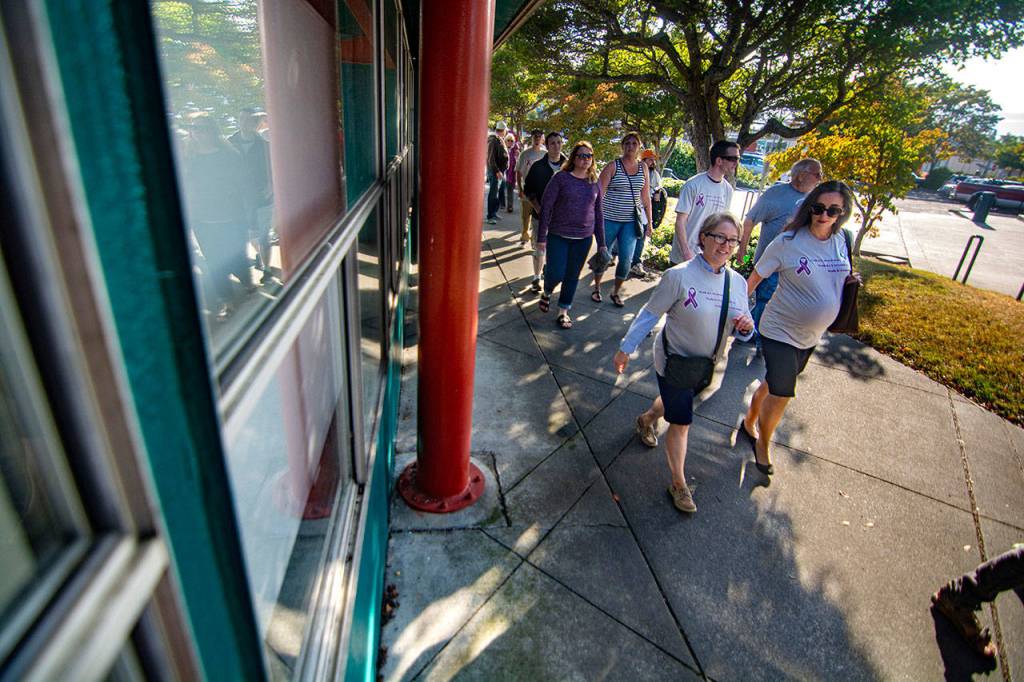 Port Angeles Deputy Mayor Kate Dexter, left, and Clallam County Health Officer Dr. Allison Unthank, right, walk in the fifth-annual Overdose Awareness Day walk in Port Angeles Saturday. (Jesse Major/Peninsula Daily News)