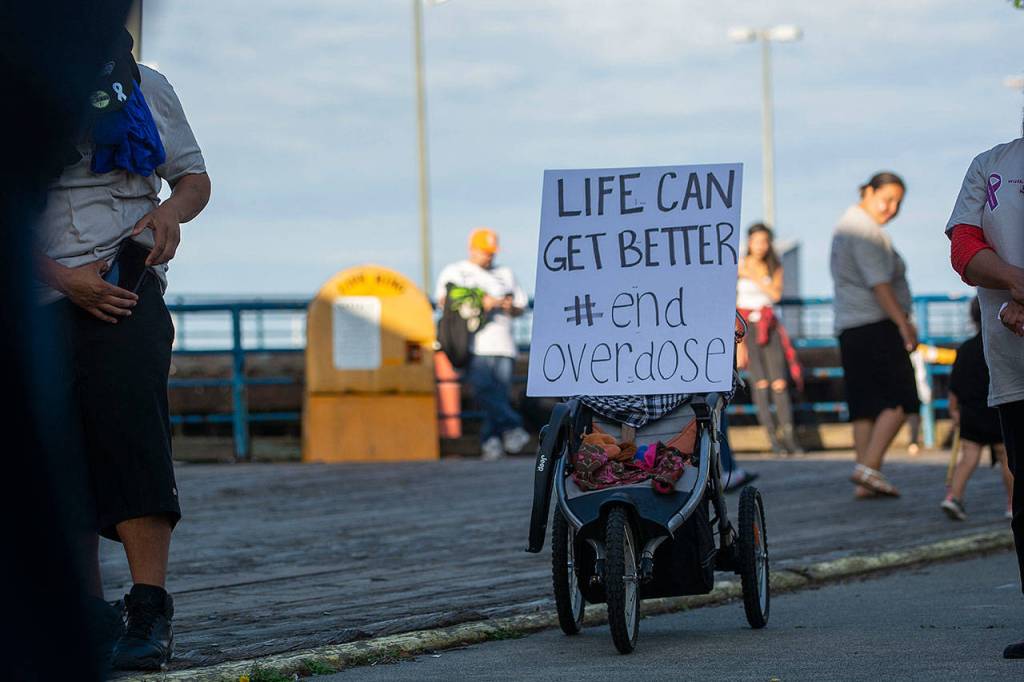 A sign sits on a stroller during the Overdose Awareness Day walk in Port Angeles Saturday. (Jesse Major/Peninsula Daily News)