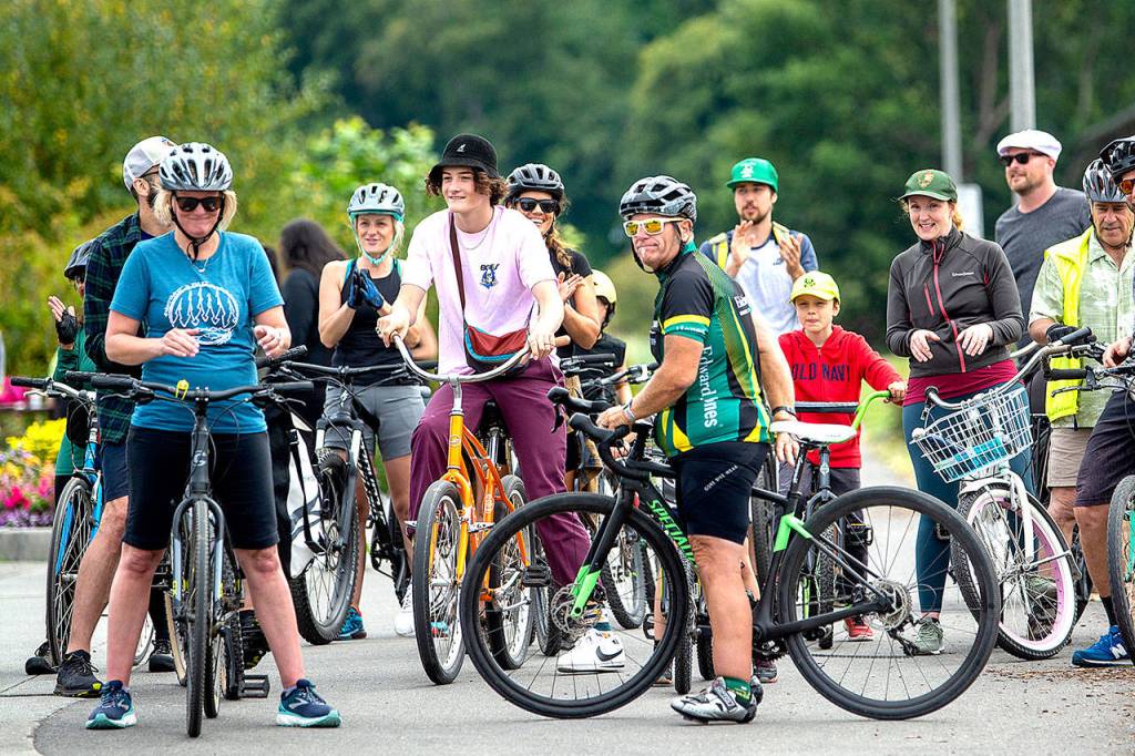 Chig Martin, on-field announcer for the Lefties, has ridden his bike every day for a year and lost 120 pounds in the process. Friends surprised Martin by joining him on his ride from Barhob to Morse Creek and back on Sunday. (Jesse Major/Peninsula Daily News)