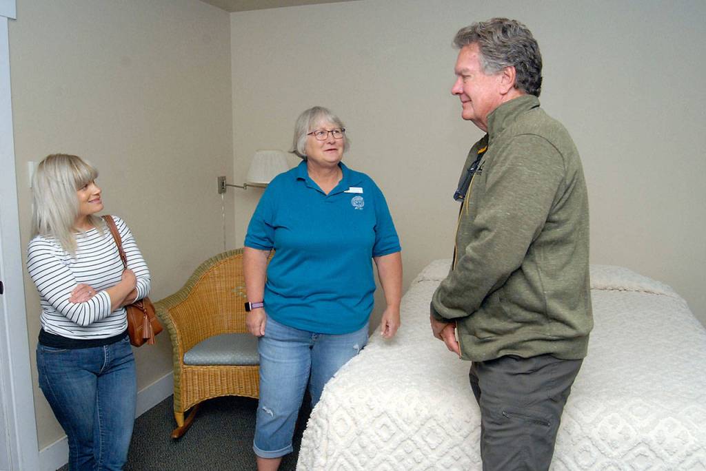 Soroptimist Patty Rosand, center, talks about the Downtown Hotel with Jennifer owens, left, and Mark Owens, both of Port Angeles. (Keith Thorpe/Peninsula Daily News)
