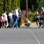 Katie Cole, Sequim associate engineer, measures a roadway as residents and consultants look on during a walking tour for the South Sequim Complete Streets project. Some residents on the tour said downtown neighborhoods are too small for new amenities and increased traffic. (Matthew Nash/Olympic Peninula News Group)
