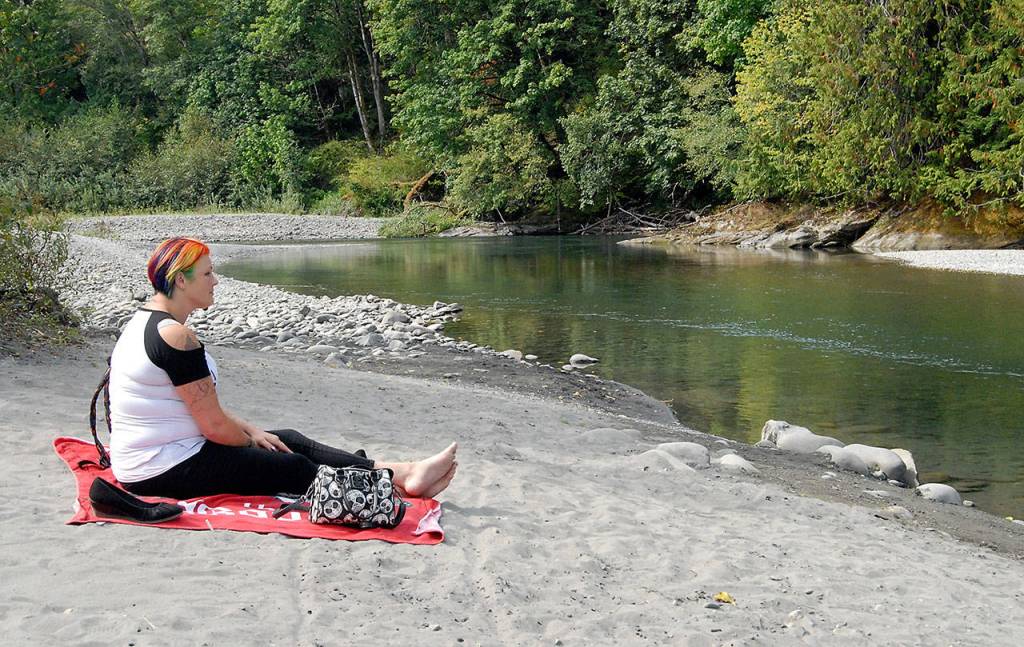 Shawna Nicholls of Port Angeles watches the Elwha River beneath the Elwha River Bridge west of Port Angeles on Thursday. Low flow rates on the river have prompted the city of Port Angeles to consider Stage 3 water restrictions. (Keith Thorpe/Peninsula Daily News)