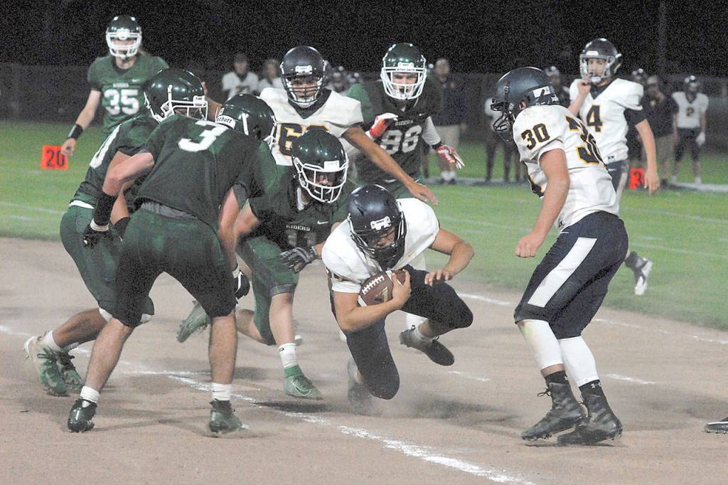 Keith Thorpe/Peninsula Daily News Forks running back Ricardo Barragan, center, dives for yardage as he tries to break through the Port Angeles defensive line in the second quarter on Friday at Port Angeles Civic Field.