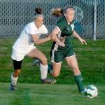 Keith Thorpe/Peninsula Daily News Port Angeles Anna Petty, right, races Bainbridges Sky Henderson to the box on Tuesday night at Port Angeles Civic Field.