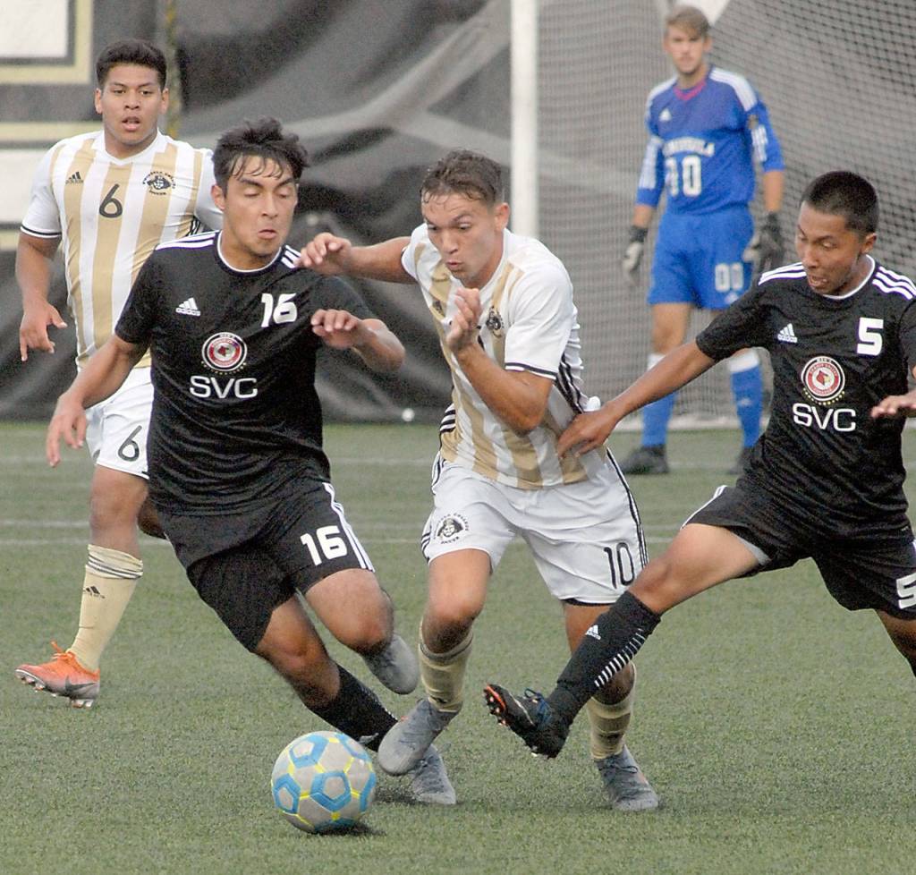 Keith Thorpe/Peninsula Daily News Peninsulas Mason Haubrich, center, gets into a foot race with Skagit Valleys Ozxami Bautista, front left, and Jorge Ramirez, right, during the first half on Wednesday in Port Angeles. Looking on from behind are Peninsulas Manny Lopez-Morales, left, and goalkeeper Evan Scholes.