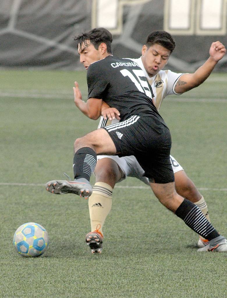 Keith Thorpe/Peninsula Daily News Peninsulas Manny Lopez-Morales, rear, gets tangled up with Skagit Valleys Ozxami Bautista on Wednesday at Wally Sigmar Field.