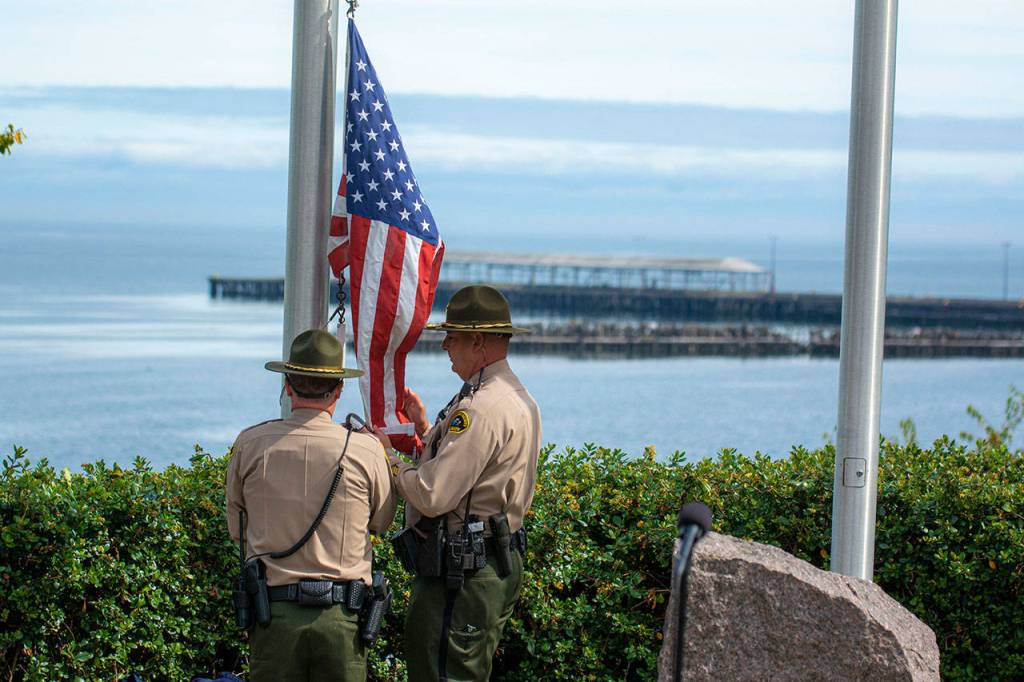 Sheriffs deputies raise the American flag during a ceremony in Port Angeles honoring public safety officials on the 18th anniversary of the 9/11 terrorist attacks Wednesday. (Jesse Major/Peninsula Daily News)
