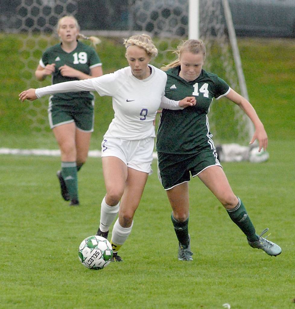 Keith Thorpe/Peninsula Daily News Sequims Eden Johnson, center, fends off Port Angeles Anna Petty, right, during the first half of play on Thursday at Port Angeles Civic Field. following from behind is Port Angeles Isabella Money.