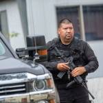 An Elwha Police officer holds his rifle before approaching a trailer at the Welcome Inn RV Park in Port Angeles on Thursday. (Jesse Major/Peninsula Daily News)