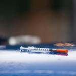 A loaded syringe sits on top of a stolen vehicle at the Welcome Inn RV Park in Port Angeles on Thursday as officers serve a search warrant. (Jesse Major/Peninsula Daily News)