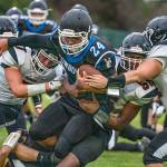 Steve Mullensky/for Peninsula Daily News Chimacums Anson Jones is brought down by three Tenino Beavers during a game on Friday in Memorial Field.