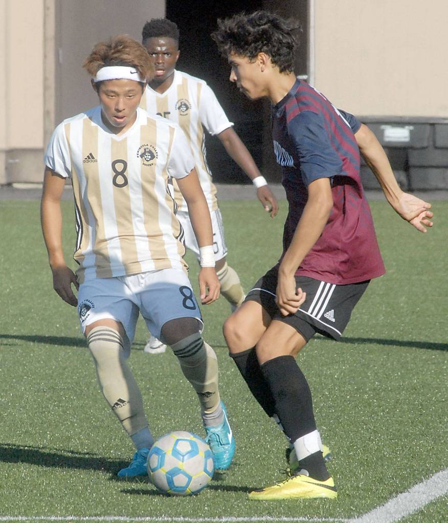 Keith Thorpe/Peninsula Daily News Peninsulas Yuya Yamamoto, left, dribbles past the defense of Whatcoms Sebastian Figueroa in the first half on Wednesday in Port Angeles.