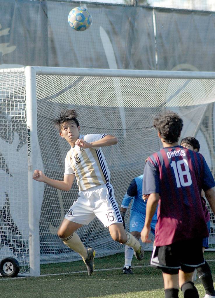 Keith Thorpe/Peninsula Daily News Peninsulas Chunghwan Lee tries to head in a corner kick as Whatcoms Sebastian Figueroa looks on at Wally Sigmar Field on Wednesday.